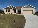 Charming one-story home featuring a two-car garage, well-manicured lawn, and beautiful exterior paint at 13480 Allentown Ave, Port Charlotte, FL 33981