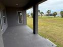 A covered back patio overlooks a grassy yard at 233 W Pine Valley Ln, Rotonda West, FL 33947