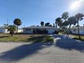 House exterior showcasing a driveway and palm trees at 1785 Elinor Pl, Englewood, FL 34223