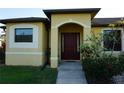 Front entrance with a dark brown door and arched entryway at 25115 Esmeralda Ct, Punta Gorda, FL 33955