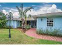 Front entrance of a light blue house with a brick pathway and porch at 27545 Monte Cristo Blvd, Punta Gorda, FL 33955