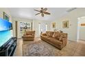 Living room with brown leather couches, large TV, and tile floors at 3474 Catskill St, Port Charlotte, FL 33952