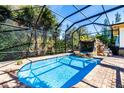 Inviting screened pool area with a stone waterfall feature at 17221 Elder Ave, Port Charlotte, FL 33954