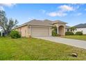 Inviting single-story home with a two car garage, manicured lawn and lush landscaping at 219 White Marsh Ln, Rotonda West, FL 33947