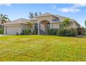 Welcoming single-story home with a covered entry, landscaping, and an attached two-car garage at 219 White Marsh Ln, Rotonda West, FL 33947