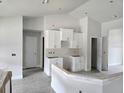 Bright, white kitchen with modern cabinets, gray tile flooring, and breakfast bar at 507 San Ambrosio St, Punta Gorda, FL 33983