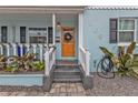 Inviting front porch with orange door and white railings at 509 W Olympia Ave, Punta Gorda, FL 33950