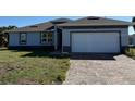 Charming single-story home featuring a brick driveway and a two-car garage at 12051 Crossgate Ave, Port Charlotte, FL 33981