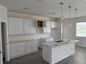 Bright, spacious kitchen with white shaker cabinets, quartz counters, and an island at 12051 Crossgate Ave, Port Charlotte, FL 33981