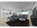 Open-concept living area with modern kitchen, dining space, and sectional sofa at 12051 Crossgate Ave, Port Charlotte, FL 33981