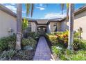 Attractive entryway with a brick-paved walkway and neatly trimmed shrubs at 12750 Oriago St, Venice, FL 34293