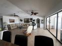 Bright living room with tile floors, large sectional, and expansive sliding glass doors to the patio at 1438 Razorbill Ln, Punta Gorda, FL 33983