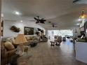 Spacious living room featuring tile floors, ceiling fans, and sliding glass doors to an outdoor patio at 1438 Razorbill Ln, Punta Gorda, FL 33983