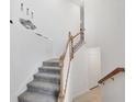 Modern staircase with gray carpeting and wood railing at 14672 Sycamore Ct # 3622, Punta Gorda, FL 33955