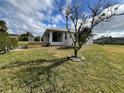 Backyard with a wooden deck, lush lawn, and a tree at 200 Dolphin Pkwy, Punta Gorda, FL 33950