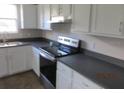 Clean kitchen with stainless steel appliances, white cabinets, and plenty of countertop space at 2410 Lanier Rd, Punta Gorda, FL 33982