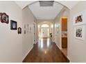 Long hallway with hardwood floors, arched doorways, and Gathering photos at 2507 Hobblebrush Dr, North Port, FL 34289