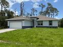 Charming single-story home featuring a well-manicured lawn, attached garage, and neutral color palette at 290 Overbrook St, Port Charlotte, FL 33954