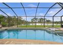 Inviting screened pool and spa overlooking a tranquil lake at 31 Tee View Pl, Rotonda West, FL 33947