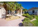 Front exterior view of a single-Gathering home with a double door entry, driveway, and lush landscaping at 3700 Candia Dr, Punta Gorda, FL 33950