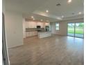 Open-concept kitchen and living area with white cabinets, stainless steel appliances, and tile floors at 384 Prineville St, Port Charlotte, FL 33954