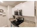 Kitchen with white cabinets, granite countertops, and stainless steel appliances at 5325 Cillette Ave, North Port, FL 34288
