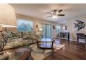 Living room with hardwood floors, floral couch, and ceiling fan at 5325 Cillette Ave, North Port, FL 34288
