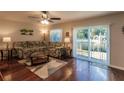 Living room with hardwood floors, floral couch, and sliding doors to backyard at 5325 Cillette Ave, North Port, FL 34288