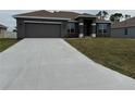 Single-story home featuring a long driveway leading to an attached two-car garage, complemented by a lush lawn at 9159 Melody Cir, Port Charlotte, FL 33981