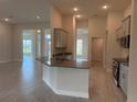 Modern kitchen with granite countertops, gray cabinets, stainless steel appliances, and tile flooring at 9159 Melody Cir, Port Charlotte, FL 33981