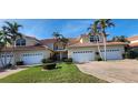 Two-story attached townhome with tile roof, white garage doors, and manicured lawn at 197 Tropicana Dr # 1512, Punta Gorda, FL 33950
