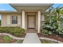 Close-up view of the front entrance, featuring a covered porch and decorative columns at 26090 Huanuco Dr, Punta Gorda, FL 33983