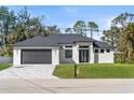 Beautifully landscaped modern home with a two-car garage and impact windows on a sunny day at 4301 Marcella Ter, North Port, FL 34286