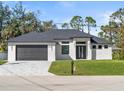 Modern single-story home with dark gray roof, two-car garage, and lush lawn at 4301 Marcella Ter, North Port, FL 34286