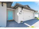 White house with teal front door and attached two-car garage at 14087 Fillmore Ave, Port Charlotte, FL 33981