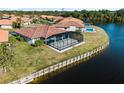 Private screened-in pool area beside the tranquil waters of the canal at 1946 Cove Pointe Dr, Venice, FL 34293