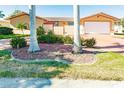 Tan house with red door and palm trees in the front yard at 69 Sabal Dr, Punta Gorda, FL 33950