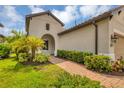 Brick pathway leads to the front entrance of the house, surrounded by lush greenery at 11137 Mcdermott Ct, Englewood, FL 34223
