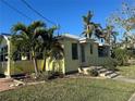 Yellow house with palm trees and a spacious yard at 205 Chasteen St, Punta Gorda, FL 33950