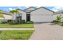 White two-story house with a brick driveway and palm trees at 2462 Gabel Oak Dr, North Port, FL 34289