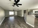 Open living area with grey walls, wood-look tile floors, and ceiling fans at 3324 Avanti Cir, North Port, FL 34287