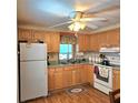 Traditional kitchen featuring wood cabinets, laminate countertops, and white appliances at 525 Parkwood Ave, North Port, FL 34287