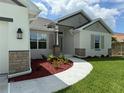 Close-up of home featuring stone accents and a garden area near the front door, plus designer exterior lighting at 9506 Melody Cir, Port Charlotte, FL 33981