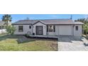 Modern single-story home with a neutral color scheme and landscaped yard at 951 Webster Nw Ave, Port Charlotte, FL 33948