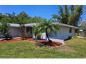 Well-kept home with a manicured lawn, palm trees, and neat landscaping at 1108 Ample Ave, Port Charlotte, FL 33948