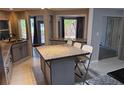 Well-lit kitchen featuring an island with a granite countertop and seating for three at 1108 Ample Ave, Port Charlotte, FL 33948