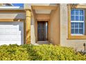 Front door entry with a decorative column and well-manicured hedges at 1916 Nottingham Trl, Punta Gorda, FL 33980