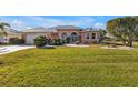 Single story home with light peach walls, gray roof and a stone driveway at 26081 Templar Ln, Punta Gorda, FL 33983