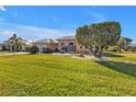 Landscaped yard with lush grass and mature trees in front of a charming home at 26081 Templar Ln, Punta Gorda, FL 33983