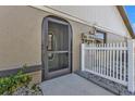 Front door entrance with screen door and white picket fence at 26155 Explorer Rd # 1C, Punta Gorda, FL 33983